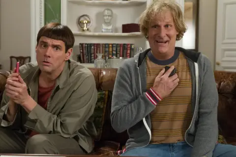 Jim Carrey och Jeff Daniels i en scen från filmer med Jim Carrey. De sitter på en soffa, båda med förvånade miner.