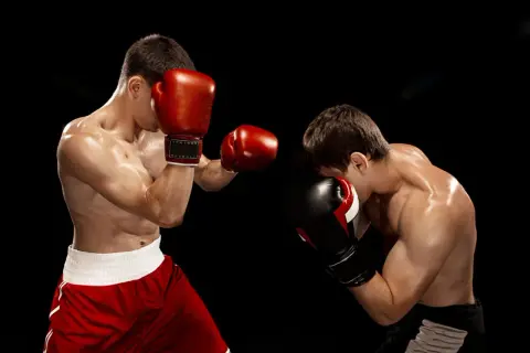 Two boxers spar intensely. The dedication shown hints at how many hours boxers train a day to reach this level of skill and conditioning.