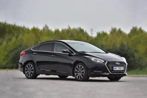 Czarny Hyundai i40 1.7 CRDi na tle drzew. Choć auto prezentuje się elegancko, warto znać jego potencjalne wady przed zakupem.