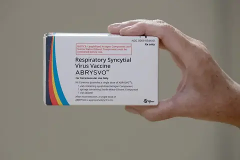 Dłoń trzyma pudełko szczepionki ABRYSVO™ przeciw wirusowi RSV.