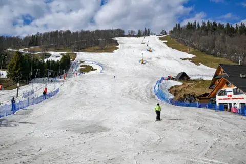 Ostatnie dni sezonu narciarskiego w Polsce. Na stoku widać nielicznych narciarzy i snowboardzistów, a także wyciągi krzesełkowe.