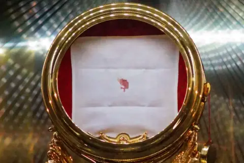 Największy cud eucharystyczny: plamka krwi na białej tkaninie w złotej monstrancji.