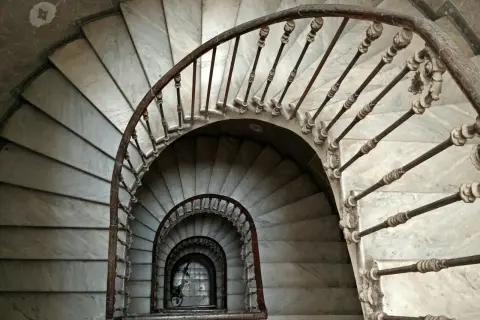 Escaleras de caracol de mármol con barandilla de hierro forjado. Un detalle de limpieza de escaleras de mármol revela su belleza clásica.