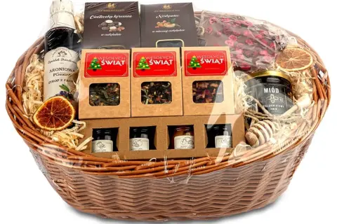 Wesołych Świąt! Kosz prezentowy świąteczny pełen słodkości: syrop aroniowy, miód, konfitury, herbaty i czekoladki.
