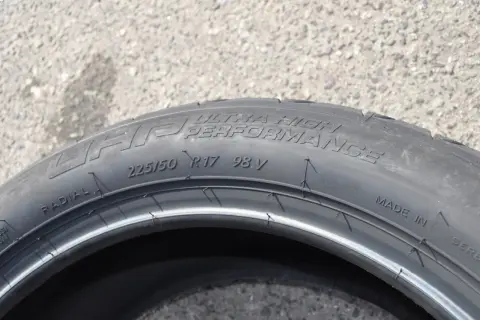 Opona samochodowa z napisem "ULTRA HIGH PERFORMANCE", rozmiar 225/50 R17 98V. Wygląda jak kormoran nurkujący w wodę.
