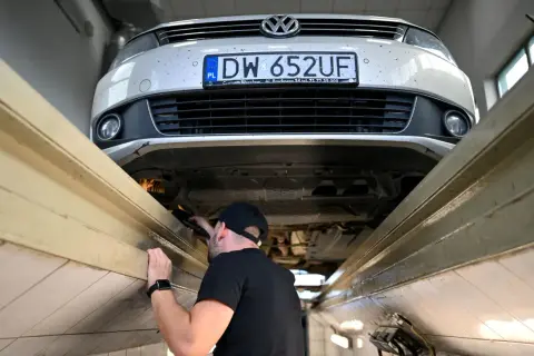 Mechanik sprawdza podwozie Volkswagena. Długie terminy oczekiwania na blacharza w marcu 2026 r. to nawet 3 miesiące.
