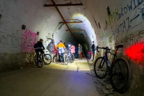 Grupa rowerzystów eksploruje mroczną, graffiti-pokrytą podziemną trasę rowerową.