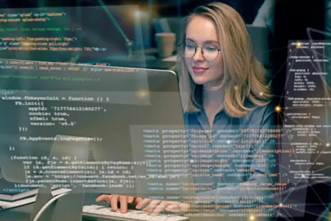 Frau lernt Programmieren im Fernstudium. Sie arbeitet konzentriert an ihrem Computer, um Fachinformatiker zu werden.