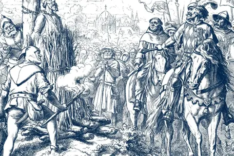 Jan Hus Tag: Ein Mann wird am Scheiterhaufen verbrannt, während Reiter und eine Menge zusehen.