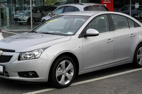 Srebrny Chevrolet Cruze na parkingu. Wiele osób szuka chevrolet cruze opinie przed zakupem.