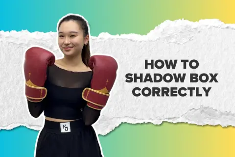 A young woman in boxing gloves smiles, ready to teach you how to shadow box correctly.