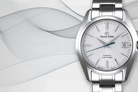 Reloj Grand Seiko automático Hi-Beat 36000, con su precisa frecuencia de reloj, sobre un fondo abstracto de líneas onduladas.