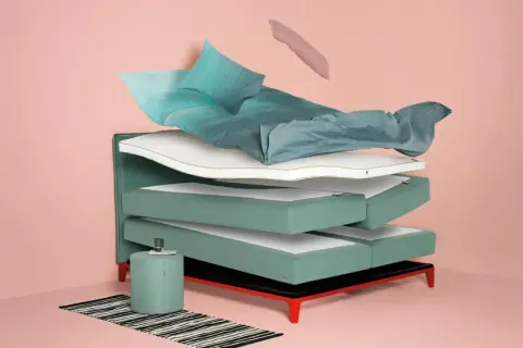 Schichtweise aufgebautes Bett mit Matratzen, Kissen und Bettwäsche. Hilft bei der Entscheidung, welches Bett passt zu mir.