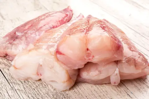 Surowe kawałki ryby miętus, gotowe do przygotowania. Ich delikatny smak zachwyci każdego smakosza.