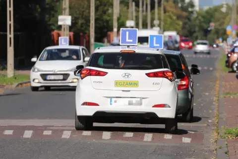 Samochody nauki jazdy z literą "L" na dachu i tabliczką "EGZAMIN" na tylnej klapie, kategoria a.