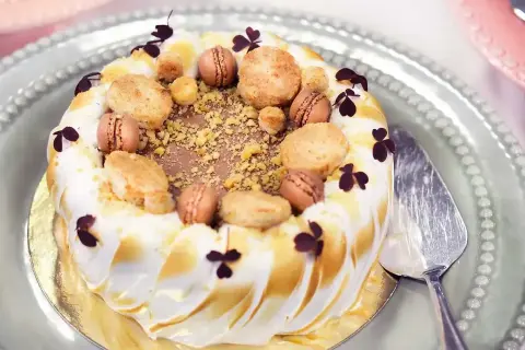 En vacker tårta med frukt och bär, dekorerad med makroner och krispiga bitar. Perfekt för ett firande!