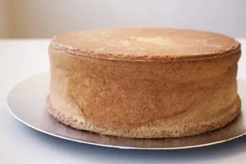 En gyllene tårtbotten, perfekt för ett tårtbotten recept 3 delar. Den ser fluffig och redo att dekoreras ut.