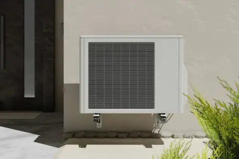 Unité extérieure de clim 2,5 kW, idéale pour une surface de 25 à 35 m². Installée près d'une porte d'entrée moderne.