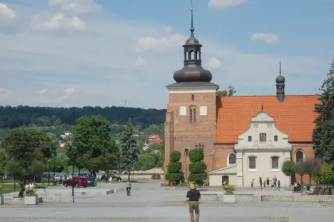 Włocławek atrakcje na weekend: plac z zabytkową katedrą, zielony park i ludzie spacerujący w słoneczny dzień.