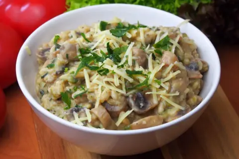 Aksamitne risotto z pieczarkami, posypane startym serem i świeżą natką pietruszki. Idealne na jesienny obiad.