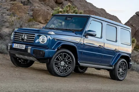 Niebieski G-wagon na pustynnym, skalistym podłożu.