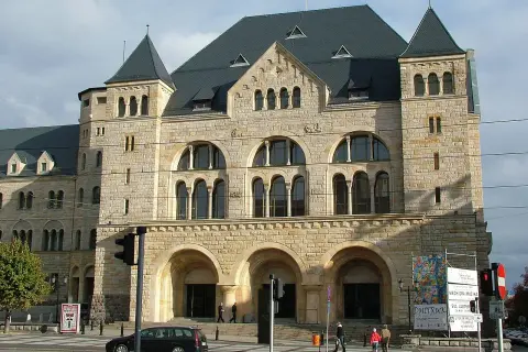 Imponujący zamek cesarski w Poznaniu, z kamienną fasadą i łukowymi oknami, przyciąga wzrok.