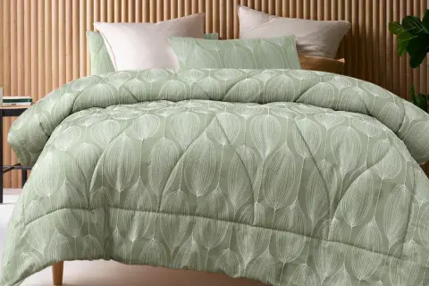 A sage green coverlet with a white leaf pattern. This coverlet serves as a decorative top layer for the bed, adding warmth and style.