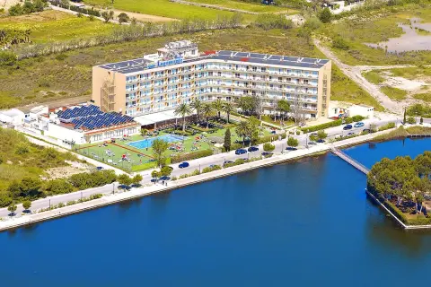 Hotel Tui Suneo Lagomonte z basenem i panelami słonecznymi, położony nad błękitną wodą.