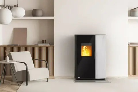 Un poêle à pellet fumée dans un salon moderne, avec une chaise confortable et une table d'appoint.