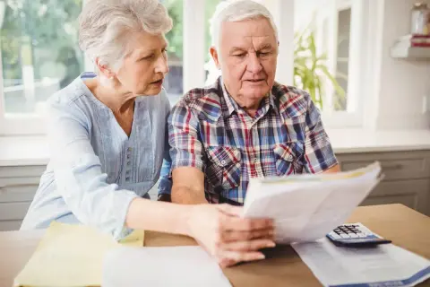 Zmartwieni seniorzy analizują dokumenty, być może dotyczące ponownego przeliczenia emerytury ZUS.