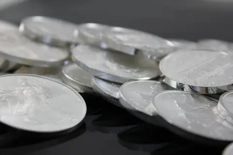 Stos monet bulionowych, symbol stabilnej srebro inwestycja. Błyszczące krążki z wizerunkami orłów i budowli.