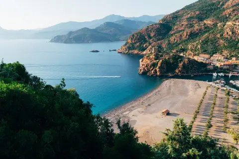Malownicza zatoka z plażą i miasteczkiem, idealne miejsce na korsyka wczasy all inclusive.