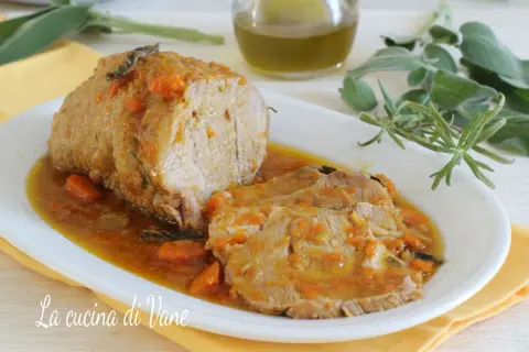 Succulento arrosto di vitello al forno, affettato e servito in un sughetto saporito con carote e erbe aromatiche.
