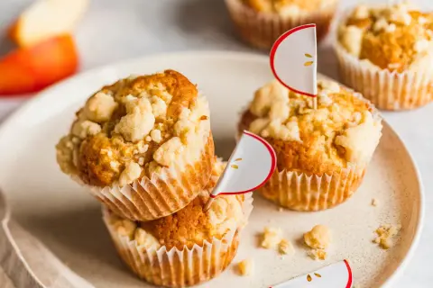 Saftige Apfel Streusel Muffins mit süßer Kruste, dekoriert mit kleinen Apfel-Fähnchen. Ein Genuss für jeden Anlass.