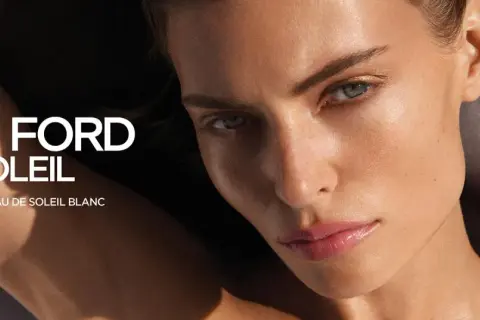 Kobieta z lśniącą skórą, obok flakonik perfum Tom Ford Soleil. Odkryj zapach Eau de Soleil Blanc.