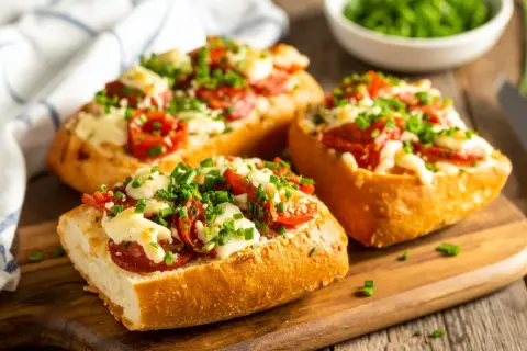 Pyszne zapiekanki z airfryer: chrupiące bagietki z serem, pomidorkami i szczypiorkiem. Idealne na szybką przekąskę.