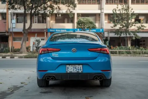 Vue arrière d'une voiture bleue. Le **code couleur voiture carte grise** est bien visible sur la plaque d'immatriculation.