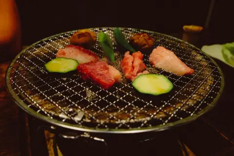Kött och grönsaker grillas på en rund grill. Ett perfekt yakiniku recept för en mysig kväll.