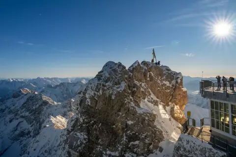 Sonnige Aussicht auf schneebedeckte Gipfel. Hier genießt man die meisten Sonnenstunden Deutschlands, umgeben von majestätischer Bergkulisse.