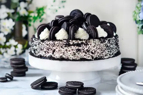 En imponerande oreo tårta, täckt med krossade kakor och dekorerad med hela oreos och fluffig grädde. Perfekt för alla kakälskare!