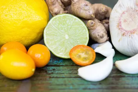 Zutaten für die Genesung: Zitrone, Limette, Kumquats, Ingwer und Knoblauch – ideal, was essen bei Grippe.