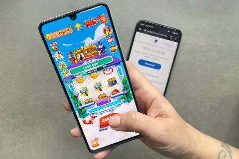 Gra Coin Master na telefonie, obok ekran z PayPalem. Czy to sposób na zarabianie przez aplikacje?