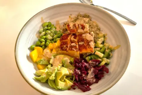 En färgstark bowl med lax, quinoa, edamamebönor, mango, avokado och rödbetor. Ett perfekt mat tips för en hälsosam lunch.