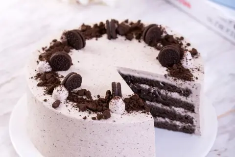Pyszny tort z masą oreo, udekorowany pokruszonymi ciasteczkami i całymi oreo. Idealny deser dla miłośników czekolady.