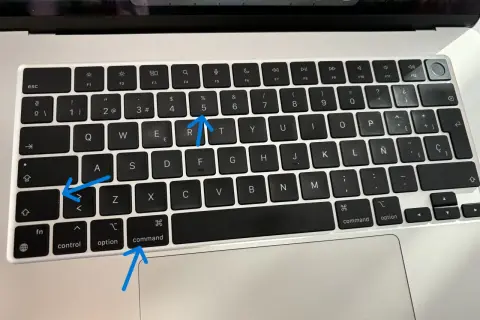 Aprende como hacer una captura de pantalla en el ordenador. Las flechas señalan las teclas Command, Shift y 5.