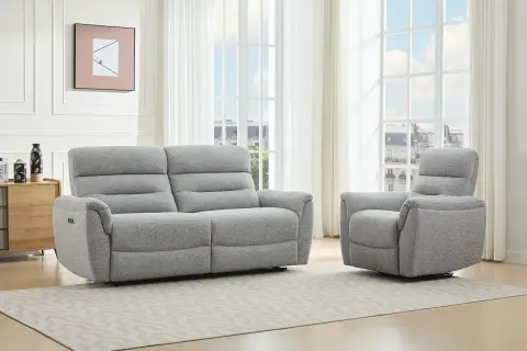 A grey recliner sofa and armchair in a bright living room with large windows.
