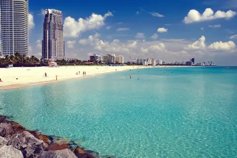 Traumhafter Strand in Miami mit türkisfarbenem Wasser und Wolken am Himmel. Perfekt für Ihre Miami Reisetipps!