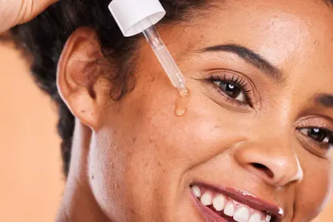 Una goccia di siero viso cade sulla pelle, rivelando il suo potere idratante e rigenerante.