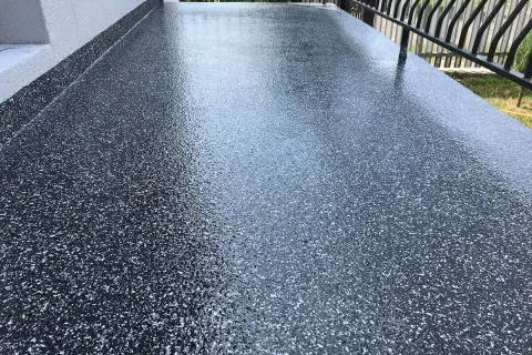 Nowoczesna żywica na balkon cena za metr. Ciemnoszara posadzka z brokatem, idealna na taras.