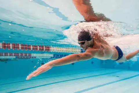 Uomo nuota in piscina, un ottimo modo per il nuoto per dimagrire e tonificare il corpo.